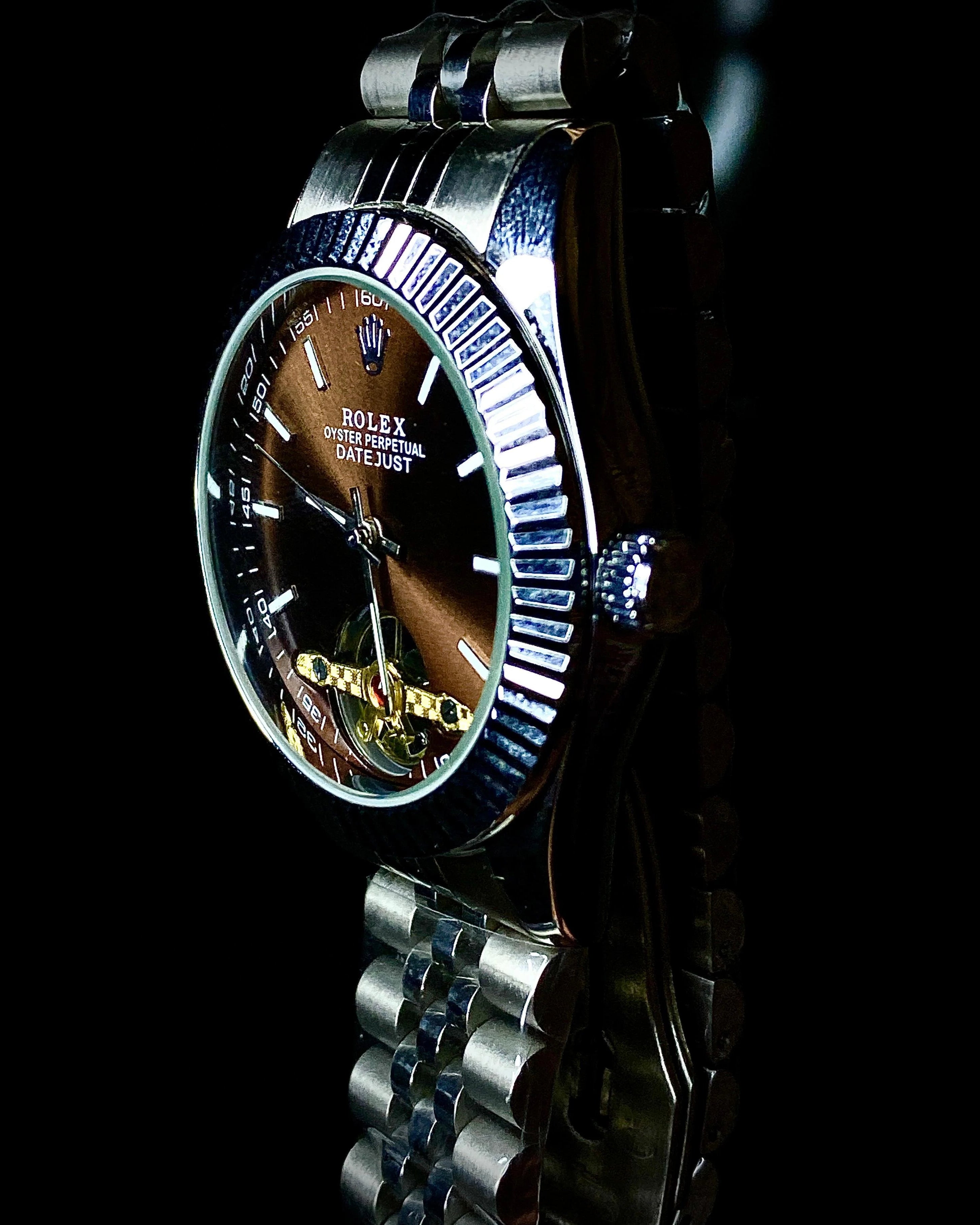 Silver watch with a detailed face on a black background